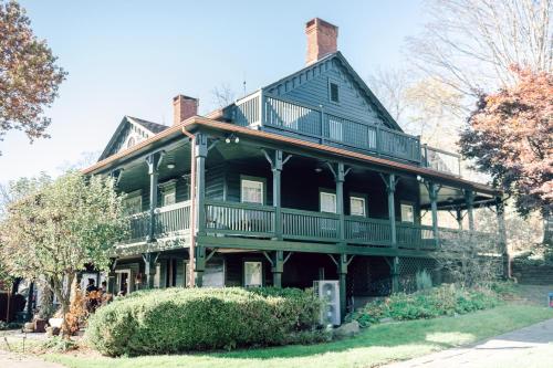 ein großes schwarzes Haus mit einer großen Veranda in der Unterkunft Fox & Bear Lodge in Glenwood