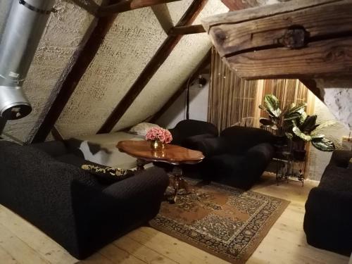 a living room with black couches and a table at Õuna Puhketalu in Jõgeva