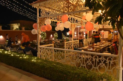 a group of people sitting at a restaurant with balloons at Hotel The Balam in Jodhpur