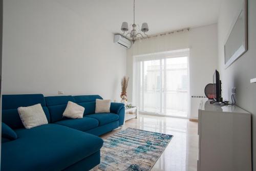 ein Wohnzimmer mit einem blauen Sofa und einem TV in der Unterkunft A Casa di Ale in Rom