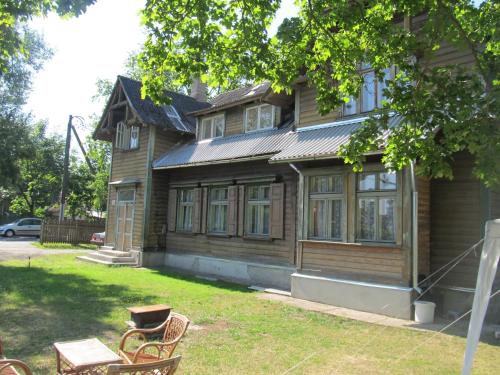 a wooden house with two benches in front of it at Frendlen Apartmend in Pärnu