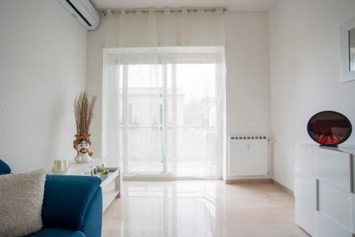 sala de estar con sofá azul y ventana grande en A Casa di Ale, en Roma