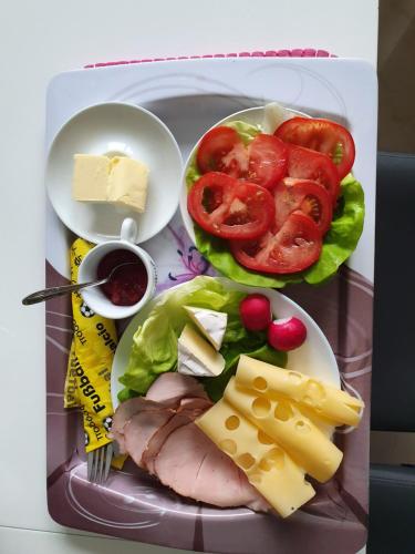 una bandeja de comida con carne, verduras y queso en Przytulny Apartamencik- Willa Lawenda, en Rytro