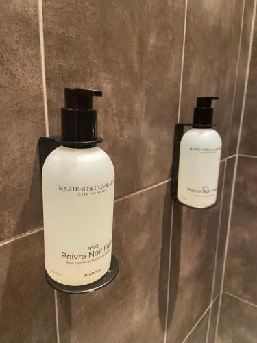 two bottles of moisturizers sitting on a tiled wall at Chez Garance Saint-Tropez in Saint-Tropez