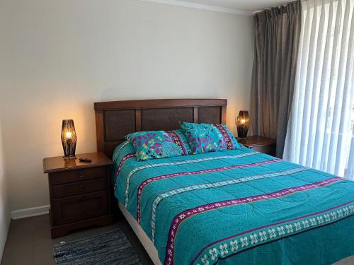 1 dormitorio con 1 cama, 2 lámparas y ventana en Excelente Departamento en Reñaca en Viña del Mar