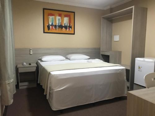 1 dormitorio con 1 cama blanca grande en una habitación en Pratico Hotel en Santarém
