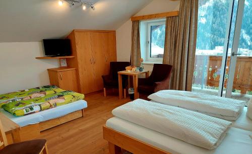 um quarto de hotel com duas camas e uma janela em Bergerhof em Kals am Grossglockner