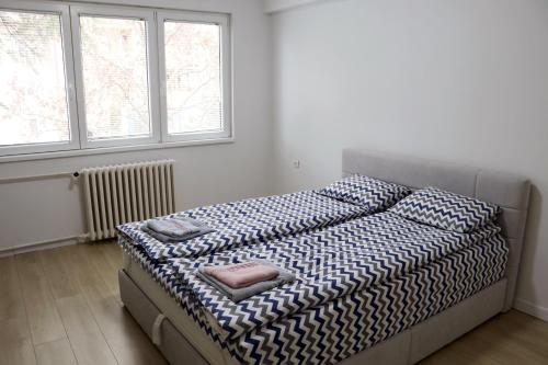 een slaapkamer met een bed met kussens erop bij Spacious modern apartment Kisela Voda in Skopje