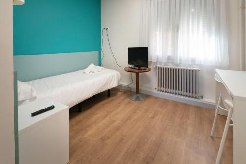 una piccola stanza con un letto e una televisione di RESIDENZA a Zamora
