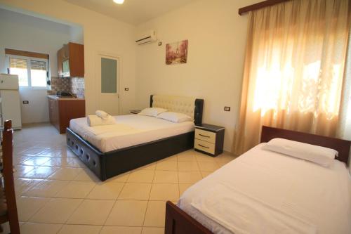 a bedroom with two beds and a kitchen at Vila Agushi in Ksamil