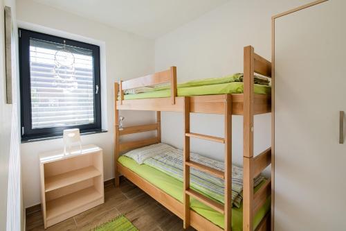 Habitación pequeña con literas y ventana en Apartmaji BANONIA " Poletni vetrc ", en Banovci