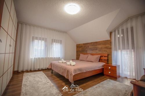 a bedroom with a bed and a large window at De La Villa Brezovice in Brezovicë