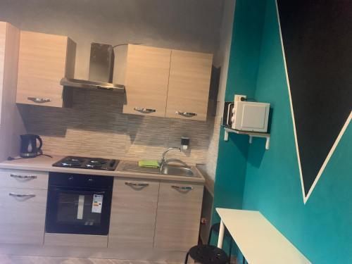 a small kitchen with a sink and a stove at Gloria Hostel Milano in Milan