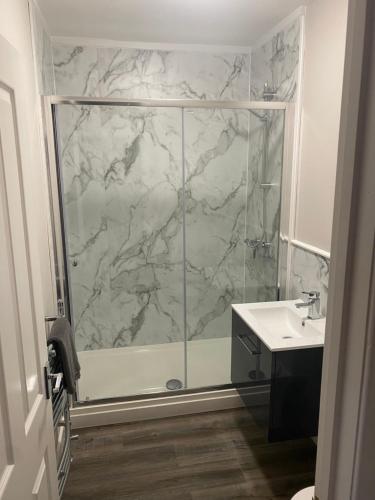 a bathroom with a shower with a glass door at THE ESK - Modern 1 bedroom apartment in centre of Melrose. in Melrose