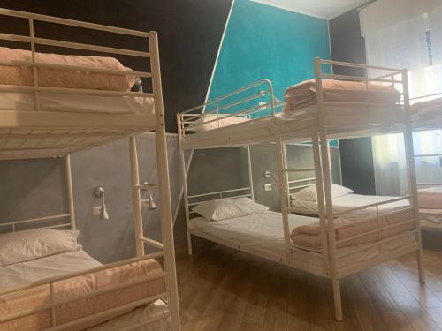 a room with three bunk beds in a room at Gloria Hostel Milano in Milan