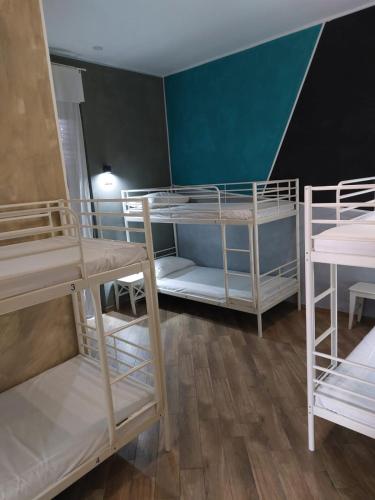 a room with three bunk beds and a staircase at Gloria Hostel Milano in Milan