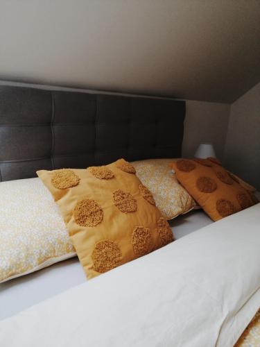 a bed with two pillows on top of it at Apartmán pri parku in Seredʼ