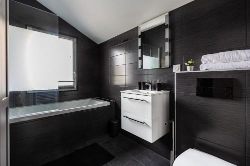 a bathroom with a bath tub and a sink at DnE VILLA- DISNEY-PARIS - HOLIDAYS HOUSE - MAISON DE VACANCES - PISCINE - POOL- 6 CHAMBRES- 6 SDB - 6 BEDROOMS - 6 BATHROOMS in Gournay-sur-Marne