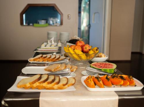 um buffet com muitos pratos de comida numa mesa em Hotel Igrejinha em Igrejinha