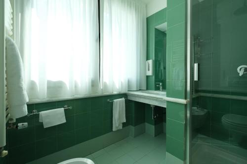 a bathroom with a shower and a toilet and a sink at Hotel Portavaldera in Peccioli