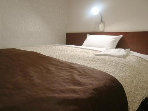 1 dormitorio con cama grande y almohada blanca en Hamamatsu Station Hotel - Vacation STAY 65843, en Hamamatsu