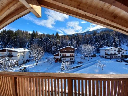 a view from the deck of a cabin in the snow at Casa Luna in Pieve di Cadore