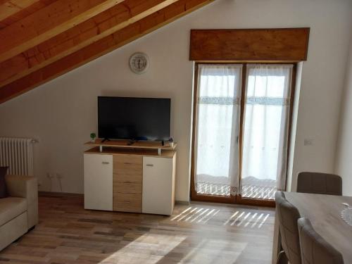 - un salon avec une télévision à écran plat et 2 fenêtres dans l'établissement Casa Luna, à Pieve di Cadore