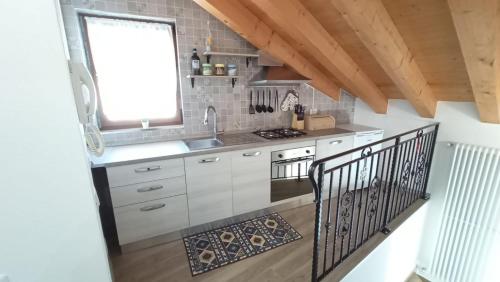a kitchen with white cabinets and a sink and a window at Casa Luna in Pieve di Cadore