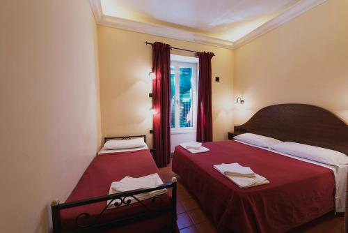 ローマにあるホテル アル サンピエトリーノの小さなベッドルーム(ベッド2台、窓付)