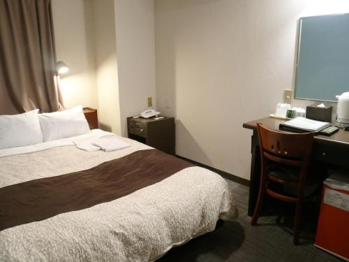 濱松的住宿－Hamamatsu Station Hotel - Vacation STAY 65830，酒店客房设有一张床和一张带显示器的书桌