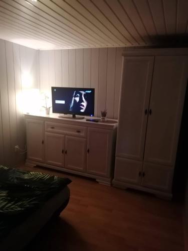 uma sala de estar com uma televisão em cima de um armário em Domek w Sławie przy jeziorze na Galerach em Sława