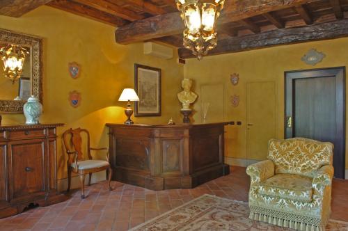 a living room with a chair and a chandelier at Hotel Torre di San Martino in Gazzola Di Rivalta