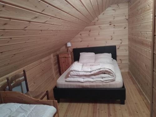 a bedroom with a bed in a wooden room at Chalet bois au milieu des Pyrénées in Soldeu lʼHospitalet