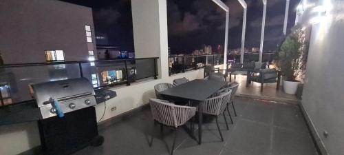 a room with a table and chairs on a balcony at AMG Suites Apartment in Santo Domingo