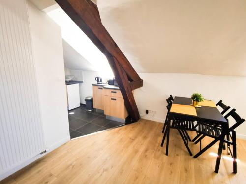 a dining room with a table and chairs and a kitchen at Appartement Cosy en Hypercentre - Le Petit Jules in Dijon
