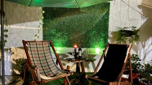 two chairs and a table with a green wall at Rincón de Kike in Villeta