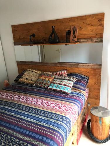 - un lit avec une tête de lit en bois et des oreillers dans l'établissement Le Dakar - T2 avec Parking offert, à Toulouse