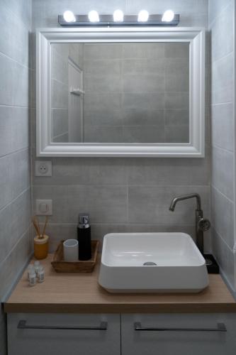 une salle de bain avec un lavabo blanc et un miroir dans l'établissement Marseille Désirée - Centre - La Joliette - gare TGV, à Marseille