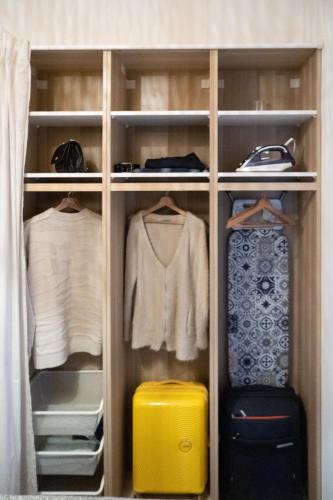 une armoire avec une valise et des vêtements jaunes dans l'établissement Marseille Désirée - Centre - La Joliette - gare TGV, à Marseille