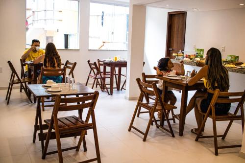 a group of people sitting at tables in a restaurant at Vila do Morro Pousada in Morro de São Paulo