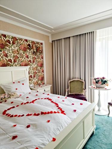 a bedroom with a bed with red roses on it at Hotel Dragului in Predeal