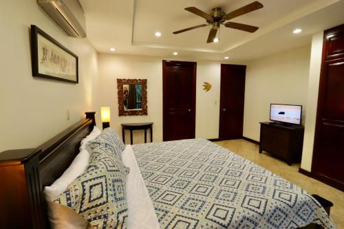 a bedroom with a bed and a ceiling fan at Monte Carlo Luxury Condominiums in Jacó