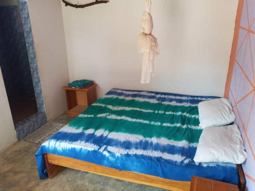 Schlafzimmer mit einem Bett mit blauer und weißer Bettwäsche in der Unterkunft Le Figuier in Pointe-Saint-Georges