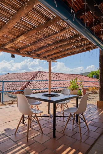 a patio with a table and chairs under a roof at Hotel Santos De Piedra - MARANATHA BARICHARA in Barichara