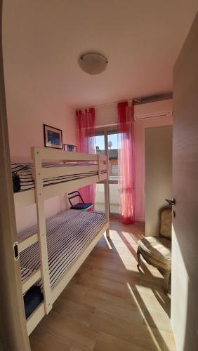 1 Schlafzimmer mit 2 Etagenbetten und einem Fenster in der Unterkunft casa vacanza fronte mare fano sassonia in Fano