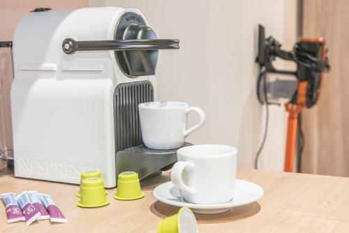 a coffee machine with two cups on a table at Centre - Le Cloud - Parking in Drulingen