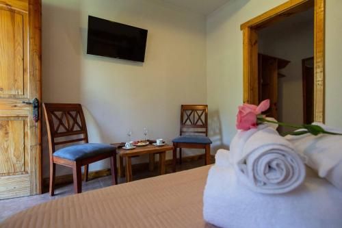 a bedroom with a bed with two chairs and a table at La Casa de Carlitos in San José de Maipo