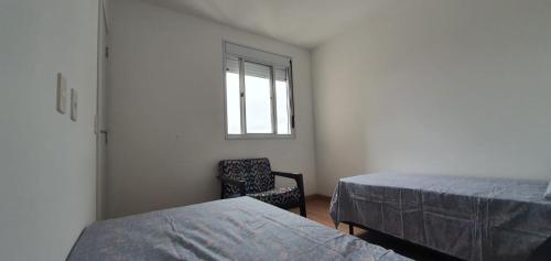 a room with two beds and a chair and a window at EXPO CENTER NORTE/VILA GUILHERME in Sao Paulo