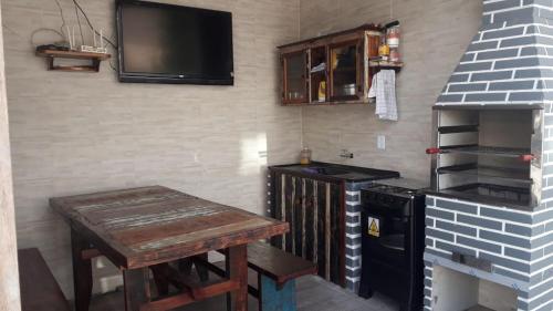een keuken met een fornuis en een tafel en een tv bij Pousada Miguel Penha Sc in Penha