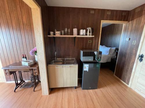 a kitchen with a refrigerator and a sink in a room at Cabañas Las Lengas in Puerto Natales